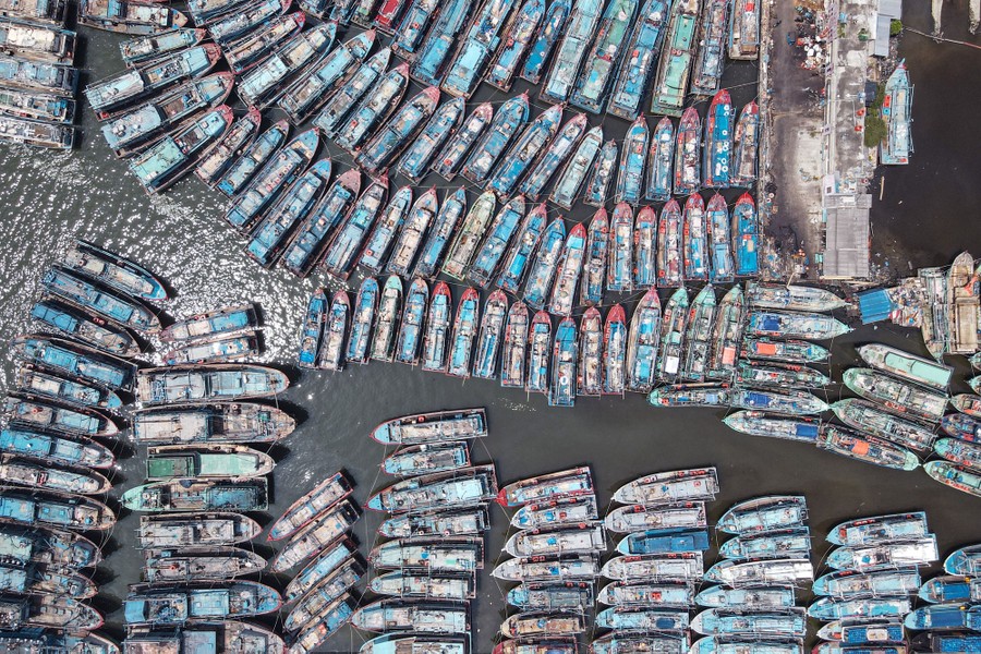 An aerial picture of many traditional fishing boats moored at a pier