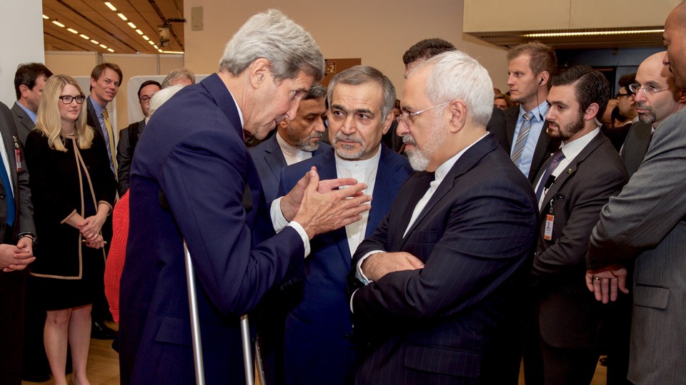 U.S. Secretary of State John Kerry speaks with Hossein Fereydoun, the brother of Iranian President Hassan Rouhani, and Iranian Foreign Minister Javad Zarif before addressing an international press corps on the nuclear deal on July 14, 2015.