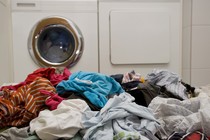 A pile of laundry in front of a washing machine