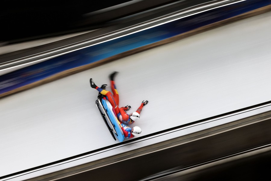 A pair of athletes fall from their sled on a luge course.
