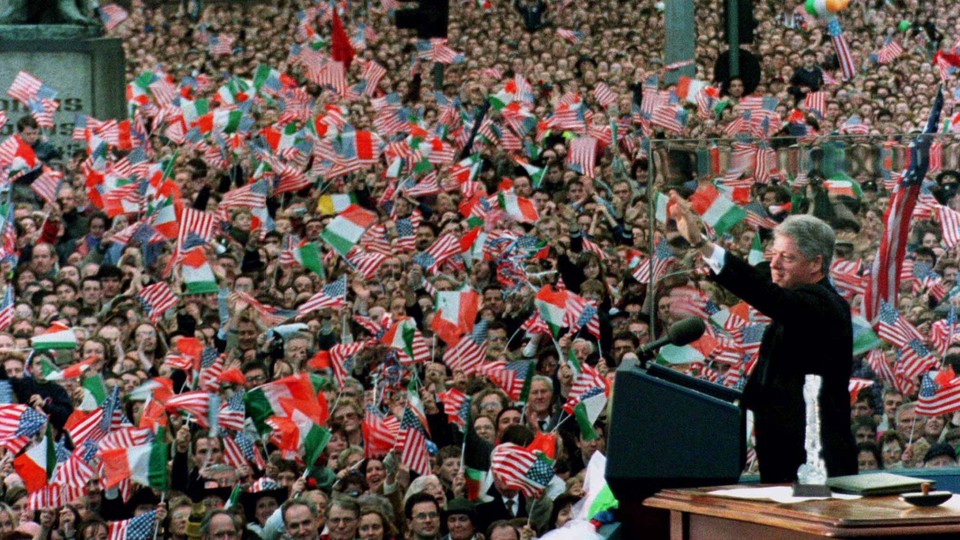 Former President Bill Clinton waves to a large crowd waving Irish and American flags in Dublin.