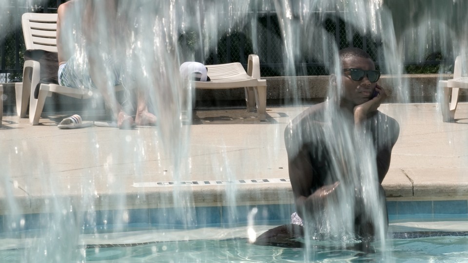 A man sits in a pool, looking bored