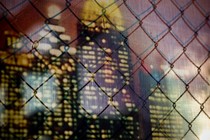 A skyline seen through a chain-link fence