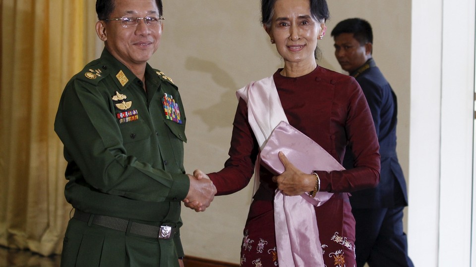 Senior General Min Aung Hlaing shakes hands with Aung San Suu Kyi.