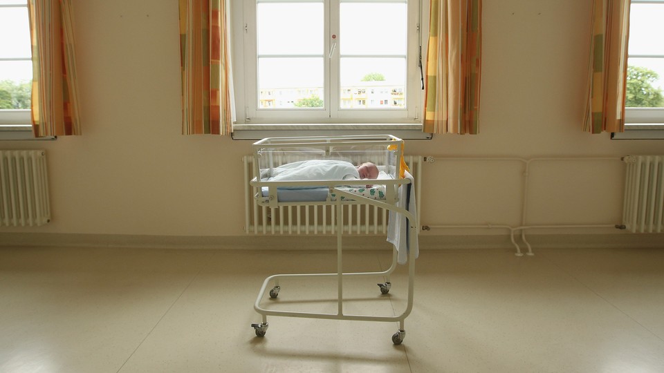 a baby in a hospital bassinet in a room
