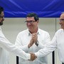 FARC lead negotiator Ivan Marquez, left, and Colombia's lead government negotiator Humberto de la Calle, right, shake hands while Cuba's Foreign Minister Bruno Rodriguez looks on, after signing a final peace deal in Havana, Cuba.