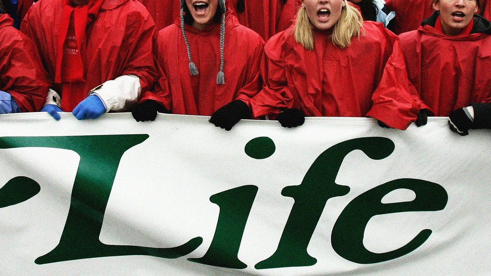 Protesters holding a sign that says "Life"