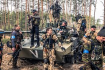 Ukrainian soldiers and foreign fighters gathered around a tank during a military operation