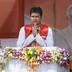 Tripura Chief Minister Biplab Kumar Deb presses his palms together and speaks at a podium adorned with flowers.