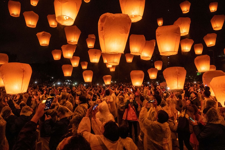 A crowd of people release hundreds of sky lanterns.