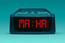 An illustration of an alarm clock with "MAHA" as the time