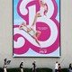 Strikers march beneath a poster for the 'Barbie' movie.