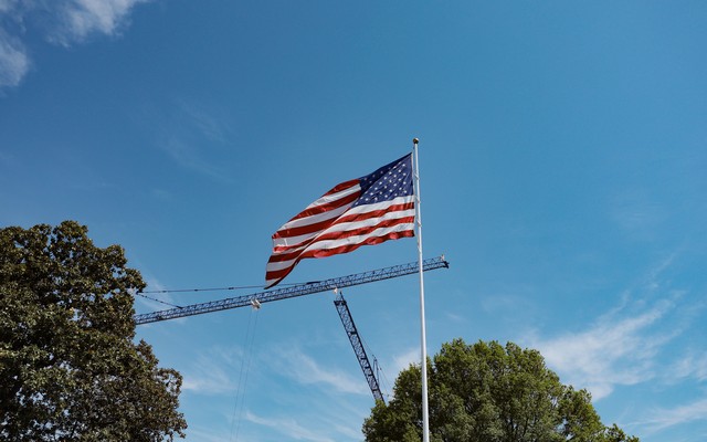 Construction cranes are seen behind a flagpole on the South Lawn of the White House on April 16, 2026.