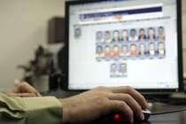 An officer looks through photos in a federal facial-recognition system