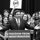 A black-and-white photograph of Ron DeSantis at a podium with his arms outstretched and a group of people standing around him holding signs against "critical race theory."