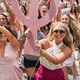 An image of sorority girls running with their Greek letters on bid day.