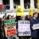 Supporters of the Hong Kong protests hold signs reading "Macau stands with Hong Kong" and "Tear gas only makes Hong Kong cry harder."