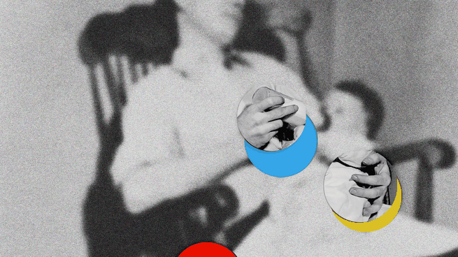 A blurry photograph of a man feeding a baby, with red, blue, and yellow moon cutouts on top