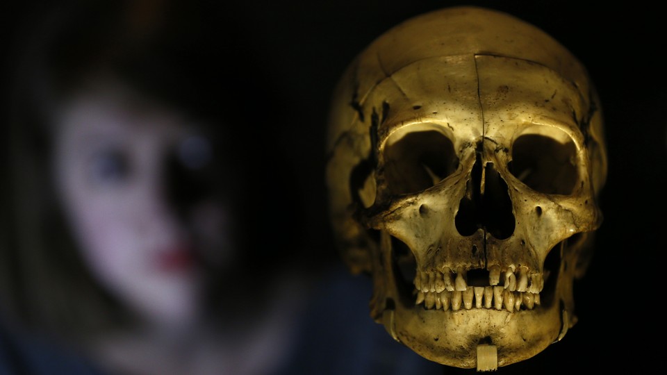 A woman looks at a human skull.