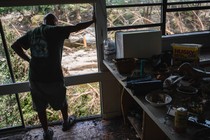 A volunteer looks out over the Guadalupe River while helping clean a resident's home in Hunt, Texas.