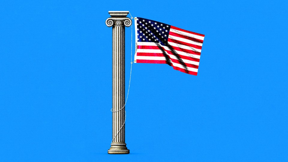 An American flag hanging from a Greek column