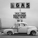 A truck parked in front of a gas sign.