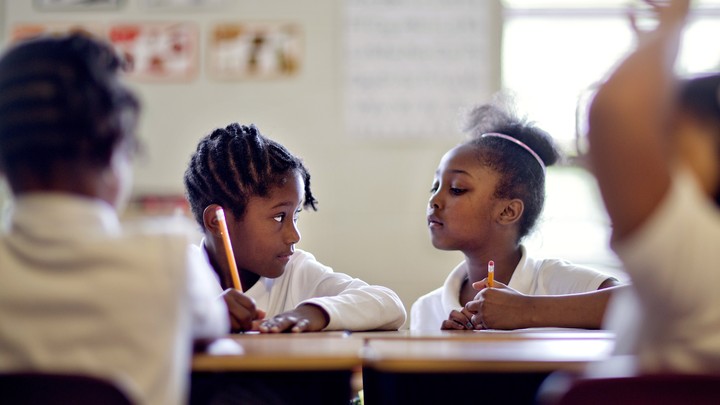 A student looks at another's worksheet. The other student gazes at her skeptically, as if to say, "You're kidding, right?"