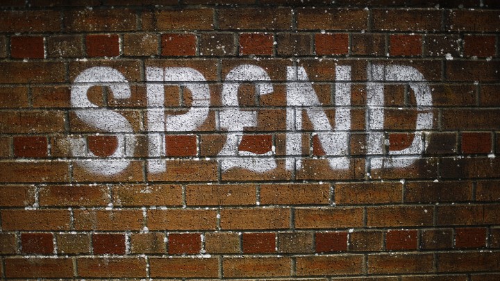 Graffiti on a brick wall in the U.K. spells out "SPEND."
