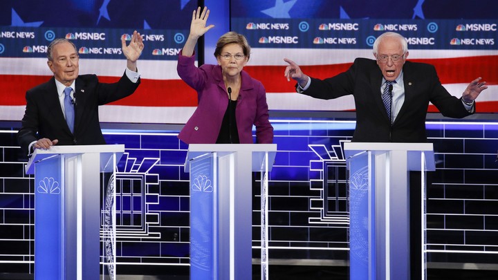 Michael Bloomberg, Elizabeth Warren and Bernie Sanders stand behind lecterns during the Democratic debate.