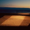 A square of light over sand on the sea