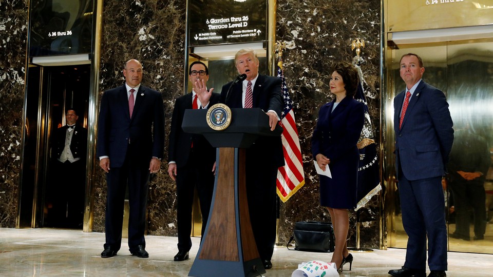 Donald Trump speaks at a podium in the lobby of the Trump Tower.