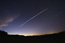 A long-exposure image of Starlink satellites passing overheard in the night sky over Uruguay
