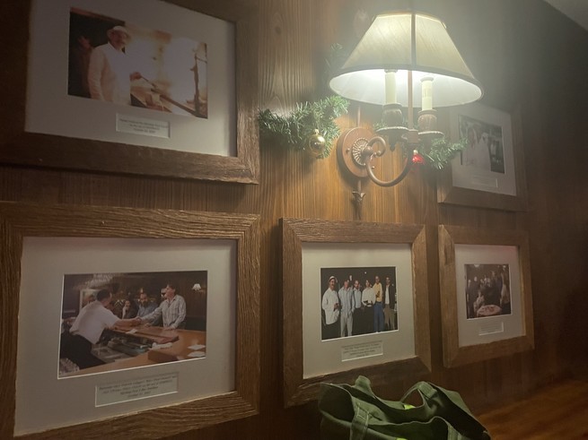 A wood-paneled wall covered with pictures from the set of the movie Sideways.