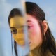 a color photograph portrait of Lorde seen through a reflective surface