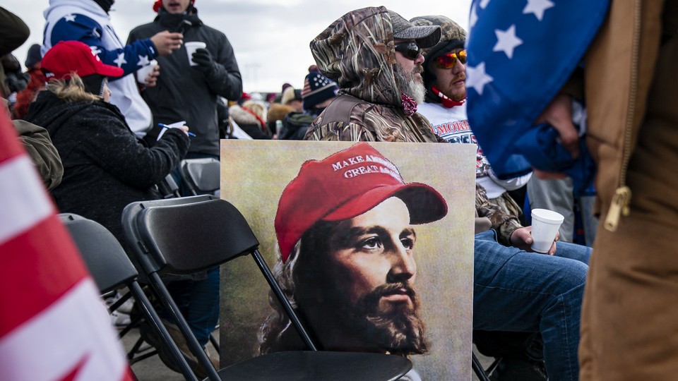 A painting of Jesus with a "Make America great again" hat leans against a chair