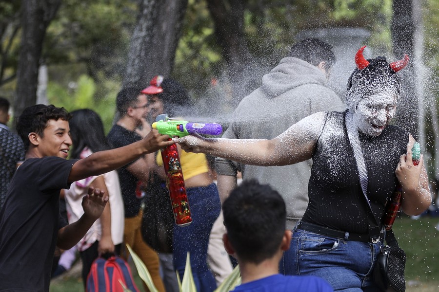A woman is sprayed with foam during a carnival parade.