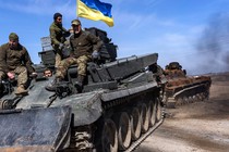 Soldiers flying a Ukrainian flag tow a damaged Russian tank from a field west of Kyiv in 2022.