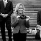 Representative Marjorie Taylor Greene smiles while holding a black face mask that reads "Stop the Steal."
