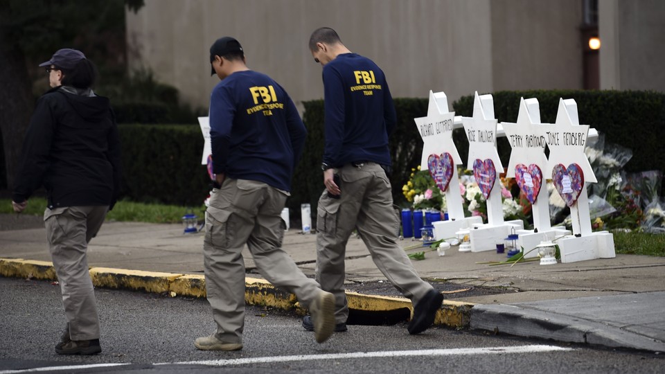 FBI officers walk past a memorial outside the Tree of Life synagogue in Pittsburgh.