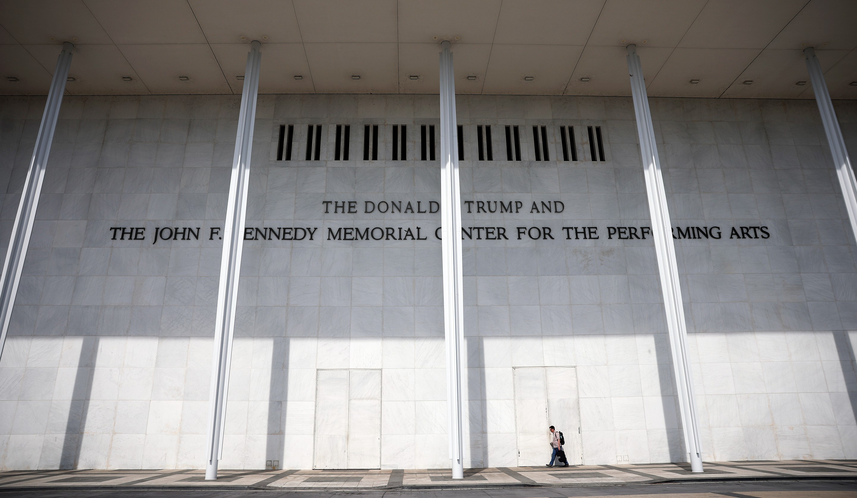 a person walks in front of the Kennedy Center 
