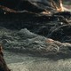 A photo of water swirling around basaltic rocks