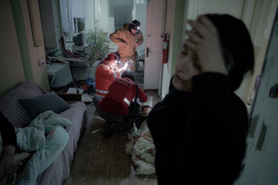 Rescue workers treat a wounded patient on the floor in a damaged hospital.