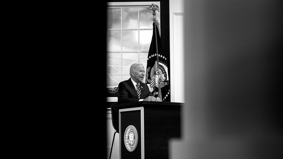 An image of President Joe Biden sitting at a desk