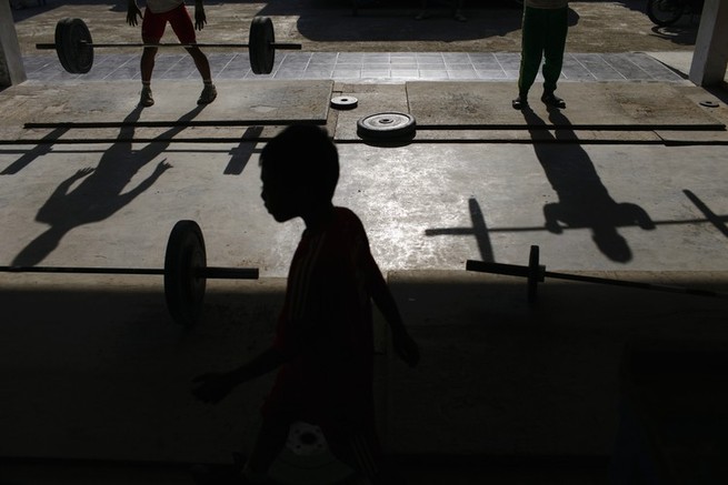 Silhouettes of boys lifting weights