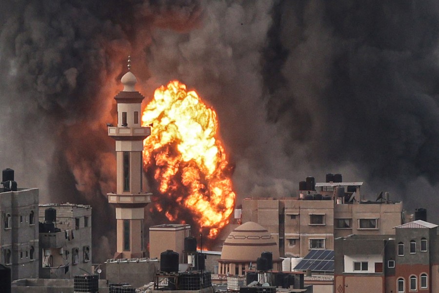 A fireball erupts among buildings in the Gaza Strip after an Israeli strike.