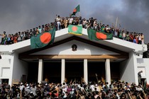 Anti-government protestors display Bangladesh’s national flag as they storm the prime minister’s palace.