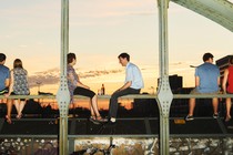 A photograph of three sets of couples watching a sunset