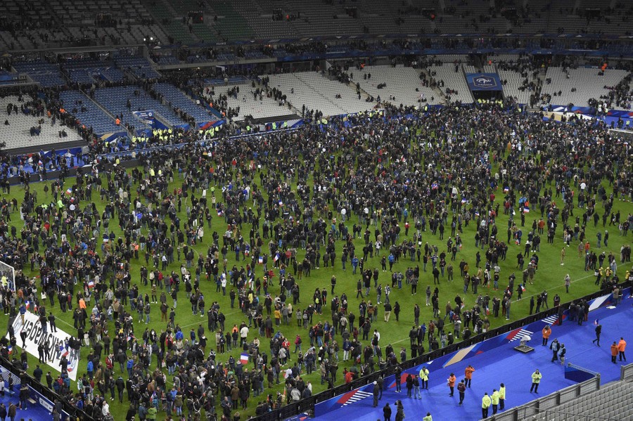 People fill the pitch of a stadium.