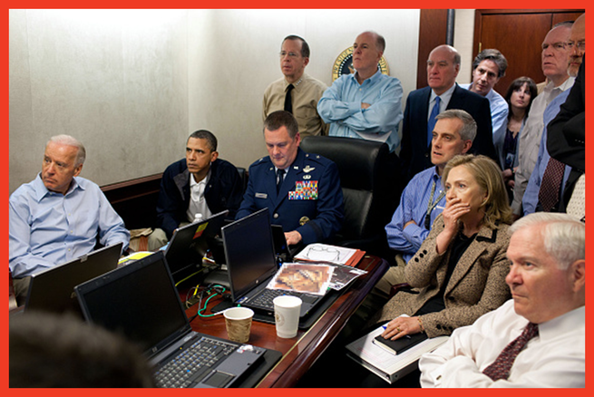 photo of assembled group in Situation Room including Biden, Obama, and members of administration surrounding table covered with laptop computers