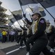 Students in black and gold marching-band uniforms hold Purdue flags and walk in tandem. 